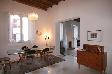Ispirazione per una sala da pranzo aperta verso il soggiorno minimalista di medie dimensioni con pareti bianche, camino classico e cornice del camino in intonaco
