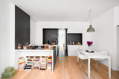 Imagen de comedor contemporáneo pequeño abierto con paredes blancas, suelo de madera clara y suelo marrón
