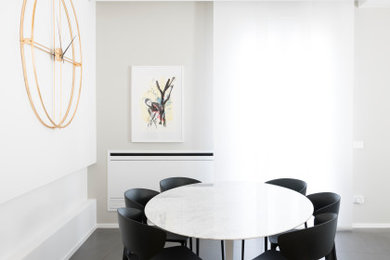 Idée de décoration pour une salle à manger ouverte sur la cuisine minimaliste de taille moyenne avec un mur blanc, un sol en bois brun, aucune cheminée et un sol gris.