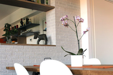 Immagine di una sala da pranzo aperta verso il soggiorno industriale di medie dimensioni con pareti grigie e pavimento in legno massello medio