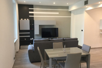 Idee per una sala da pranzo aperta verso il soggiorno minimal con pareti bianche, pavimento in gres porcellanato e pavimento grigio