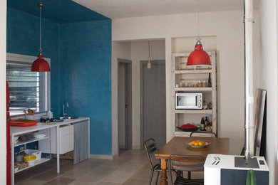 Foto di una sala da pranzo aperta verso la cucina minimalista di medie dimensioni con pavimento in pietra calcarea, stufa a legna e pareti grigie
