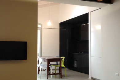 Ispirazione per una sala da pranzo aperta verso il soggiorno minimal di medie dimensioni con pareti bianche, pavimento in cemento e pavimento grigio