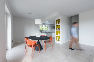 Foto di una sala da pranzo aperta verso il soggiorno contemporanea di medie dimensioni con pareti grigie, pavimento in gres porcellanato e pavimento beige