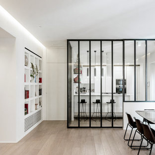 Foto di una sala da pranzo minimal con pareti bianche, parquet chiaro e pavimento beige