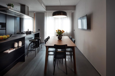 Immagine di una sala da pranzo aperta verso la cucina minimalista di medie dimensioni con pareti grigie