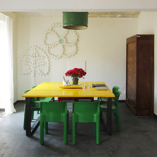 Ispirazione per una sala da pranzo bohémian con pareti bianche, pavimento nero e pavimento in cemento