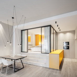 Idee per una sala da pranzo aperta verso il soggiorno design con pareti grigie, parquet chiaro e pavimento beige