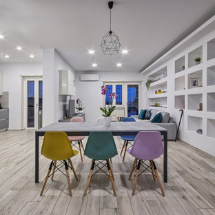 Immagine di una sala da pranzo aperta verso il soggiorno minimal con pareti bianche e pavimento grigio