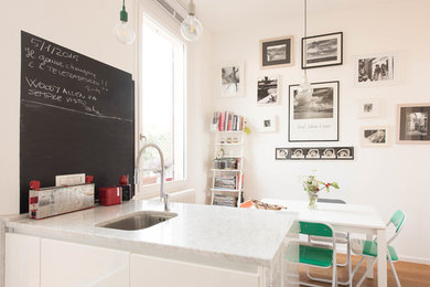 Moderne Wohnküche mit weißer Wandfarbe, braunem Holzboden und braunem Boden in Bologna