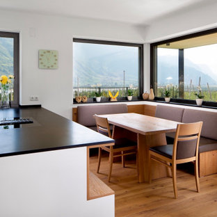 Foto di una sala da pranzo aperta verso la cucina minimal di medie dimensioni con pavimento in legno massello medio, pareti bianche e pavimento beige
