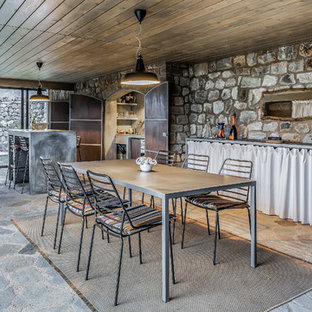 Idee per una sala da pranzo aperta verso la cucina mediterranea con nessun camino e pavimento grigio