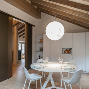 Foto di una sala da pranzo aperta verso la cucina minimal di medie dimensioni con pareti bianche, parquet chiaro e pavimento beige