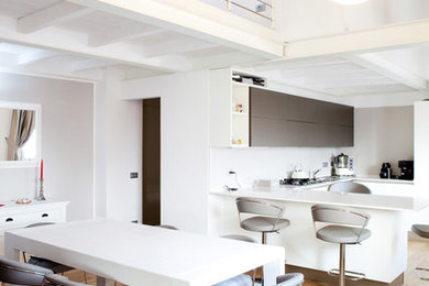 Idee per una sala da pranzo aperta verso la cucina design di medie dimensioni con pareti bianche e parquet chiaro