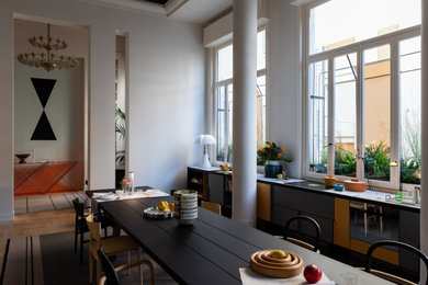 Foto di una sala da pranzo aperta verso la cucina contemporanea con pareti grigie, pavimento in legno massello medio e pavimento marrone