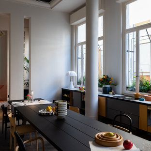 Foto di una sala da pranzo aperta verso la cucina contemporanea con pareti grigie, pavimento in legno massello medio e pavimento marrone