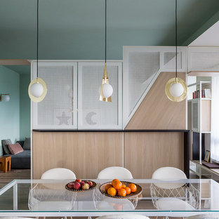 Immagine di una sala da pranzo design con pareti verdi, pavimento in legno massello medio e pavimento marrone