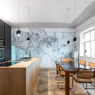 Immagine di una sala da pranzo aperta verso la cucina minimal con pareti grigie, pavimento in legno massello medio e pavimento marrone