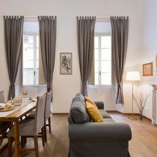 Foto di una sala da pranzo design con pareti bianche, pavimento in legno massello medio, camino classico e pavimento marrone