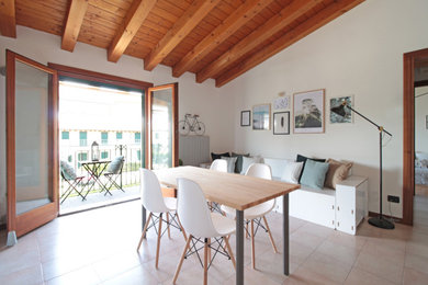 Immagine di una sala da pranzo aperta verso la cucina minimalista di medie dimensioni con pareti bianche, pavimento in gres porcellanato e pavimento beige