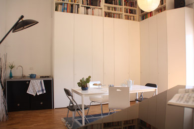 Ispirazione per una sala da pranzo aperta verso la cucina stile marino di medie dimensioni con pareti bianche, pavimento in legno massello medio e pavimento marrone