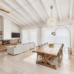 Immagine di una sala da pranzo aperta verso il soggiorno country con pareti bianche, camino lineare Ribbon e pavimento beige