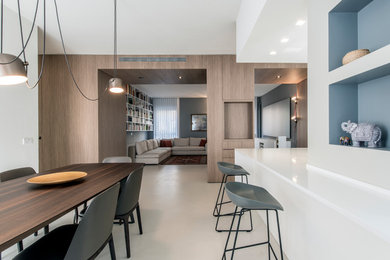 Idee per una grande sala da pranzo aperta verso il soggiorno contemporanea con pareti bianche, pavimento in cemento e pavimento bianco