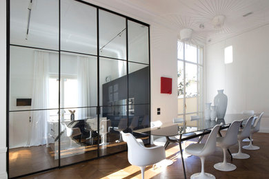 Foto di una grande sala da pranzo aperta verso la cucina minimal con pareti bianche e parquet chiaro