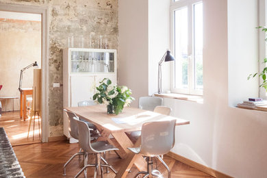 Foto di una sala da pranzo aperta verso la cucina contemporanea di medie dimensioni con pareti bianche e pavimento in legno massello medio