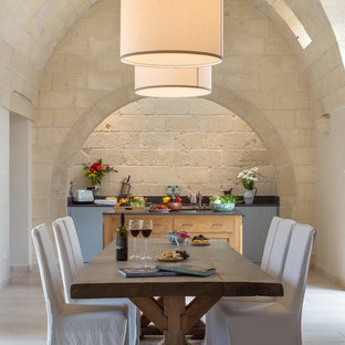 Esempio di una sala da pranzo aperta verso la cucina mediterranea con pareti beige e pavimento grigio