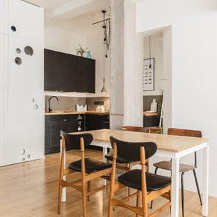 Immagine di una piccola sala da pranzo aperta verso la cucina design con pareti bianche, parquet chiaro e nessun camino