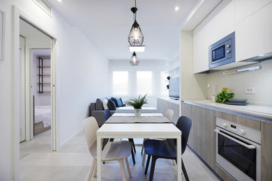 Esempio di una piccola sala da pranzo aperta verso la cucina contemporanea con pareti bianche, pavimento con piastrelle in ceramica, nessun camino e pavimento grigio