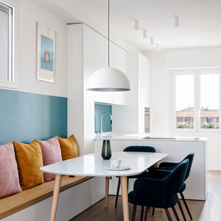 Immagine di una sala da pranzo aperta verso la cucina contemporanea di medie dimensioni con pavimento in legno massello medio, pareti bianche e pavimento marrone