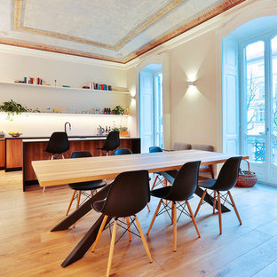 Immagine di una grande sala da pranzo aperta verso la cucina design con pareti bianche, pavimento in legno massello medio e pavimento marrone