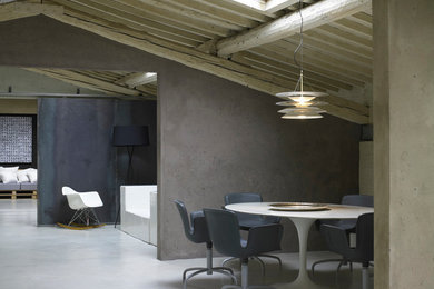 Foto di una sala da pranzo industriale con pareti grigie e pavimento in cemento