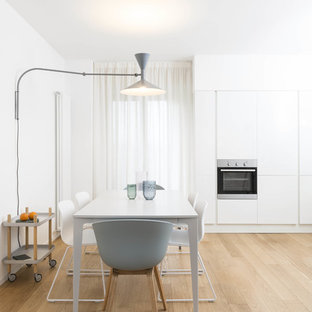 Ispirazione per una sala da pranzo aperta verso la cucina nordica con pareti bianche, parquet chiaro e pavimento beige