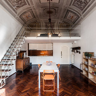 Esempio di una sala da pranzo aperta verso il soggiorno mediterranea con pareti bianche, parquet scuro e pavimento marrone
