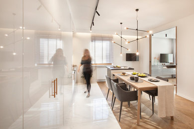 Idee per una sala da pranzo aperta verso la cucina minimalista di medie dimensioni con pareti bianche, pavimento in gres porcellanato e pavimento bianco