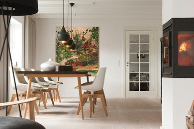 Inspiration pour une salle à manger nordique de taille moyenne avec un mur blanc, parquet clair et une cheminée d'angle.
