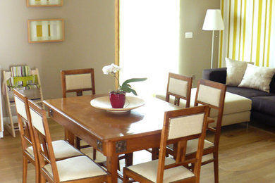 Cette photo montre une grande salle à manger ouverte sur le salon moderne avec un mur gris, un sol en bois brun et aucune cheminée.