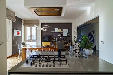 Immagine di una grande sala da pranzo aperta verso il soggiorno moderna con pareti grigie, parquet chiaro e pavimento marrone