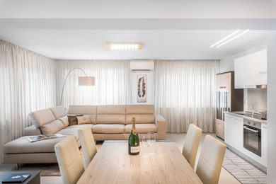 Foto di una piccola sala da pranzo aperta verso il soggiorno design con pareti bianche, pavimento in gres porcellanato e pavimento beige