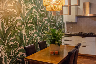 Esempio di una sala da pranzo aperta verso la cucina moderna di medie dimensioni con pareti verdi, parquet scuro, nessun camino e pavimento marrone