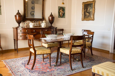 Immagine di una grande sala da pranzo aperta verso il soggiorno tradizionale con pareti beige e parquet chiaro