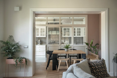 Idee per una grande sala da pranzo aperta verso la cucina design con pareti rosa, parquet chiaro e pavimento marrone