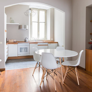 Foto di una piccola sala da pranzo nordica con pavimento marrone, nessun camino, pareti grigie e pavimento in legno massello medio