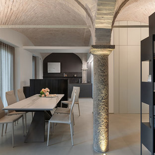 Immagine di una sala da pranzo mediterranea con pareti bianche e pavimento grigio