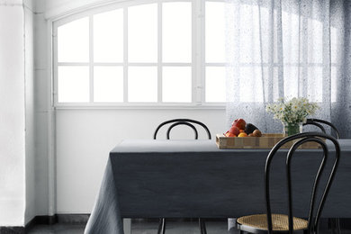 Immagine di una sala da pranzo aperta verso la cucina industriale di medie dimensioni con pareti bianche, pavimento in cemento e pavimento grigio