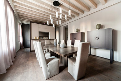 Immagine di una sala da pranzo aperta verso il soggiorno minimal con pareti beige, pavimento in legno massello medio, nessun camino e pavimento marrone