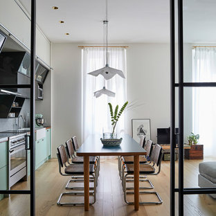 Foto di una sala da pranzo aperta verso il soggiorno minimal di medie dimensioni con pareti bianche, parquet chiaro e pavimento beige